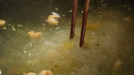 cooking glass noodles soup with chopsticks