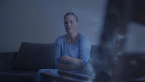 animation of caucasian woman sitting on couch over storm