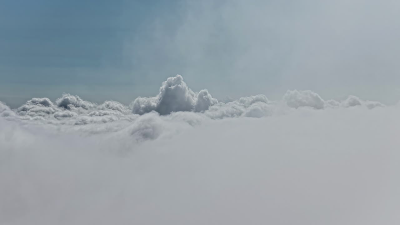 Cumulus clouds large puffy white cotton balls high altitude airplane window view