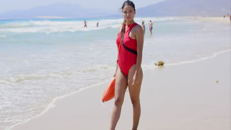 Frau-Im-Rettungsschwimmer-Outfit-Am-Strand-Mit-Schwimmern