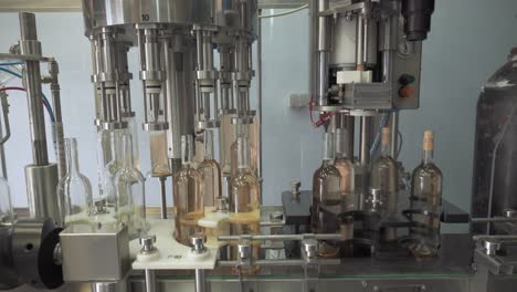 automatic machines for filling and corking bottles of rose wine at factory