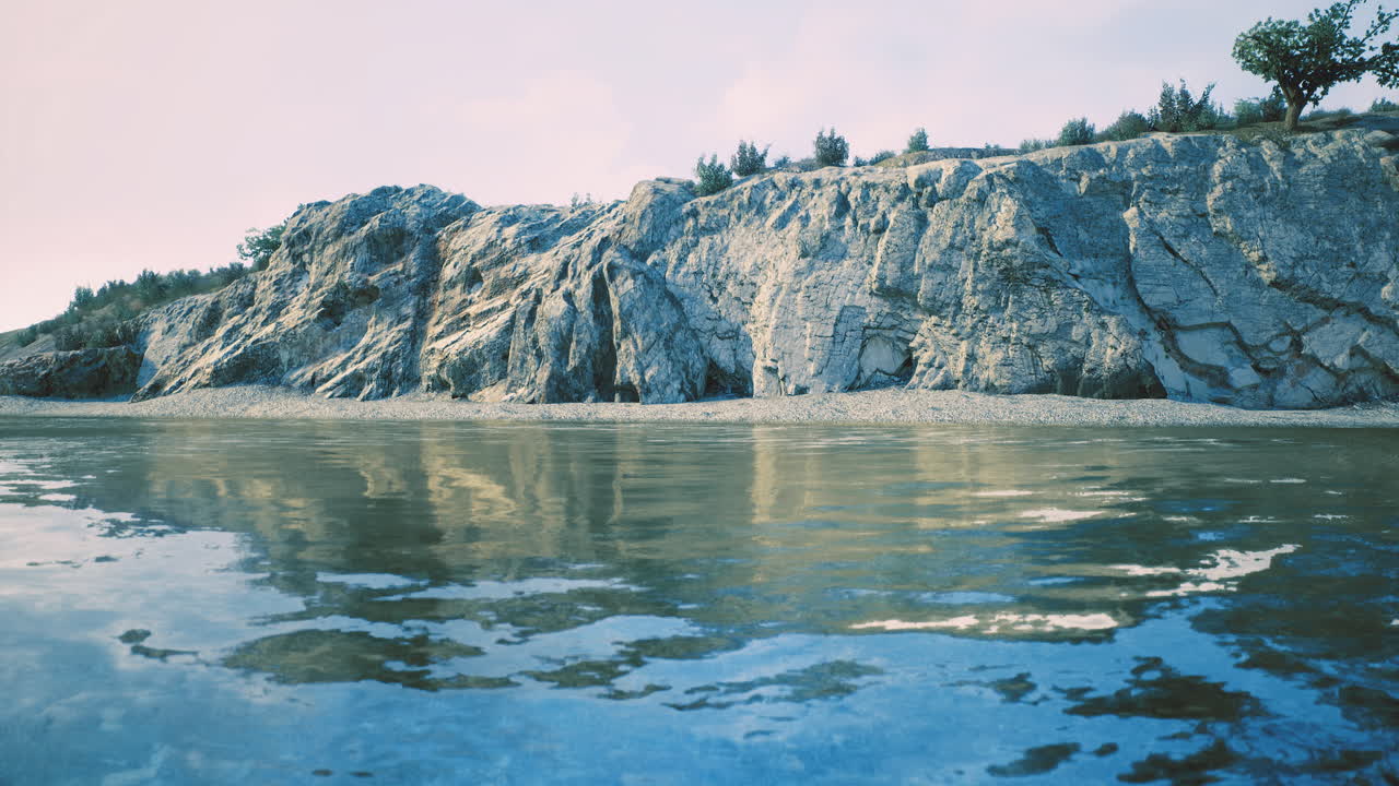 Serene coastal landscape with rocky cliffs and calm water reflecting the sky