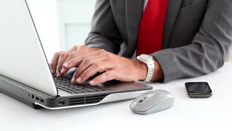 businessman using laptop and typing on his phone