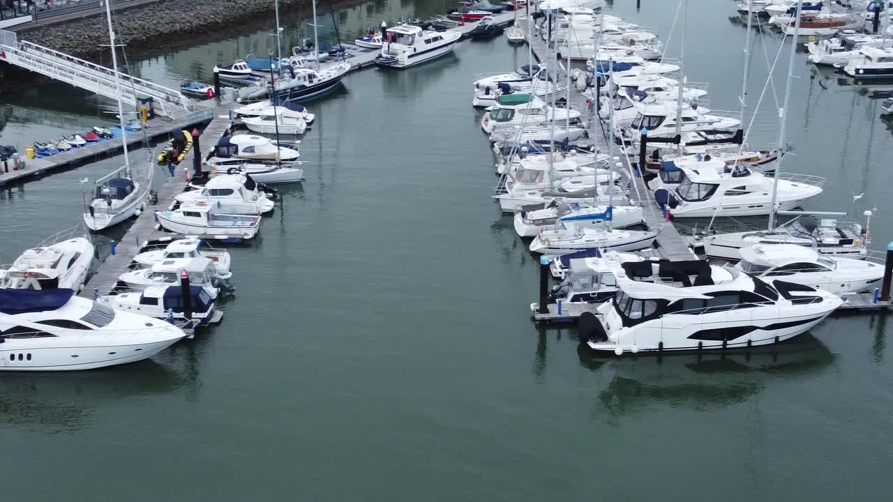 Aerial Birdseye view across wealthy luxury yachts and sailing boats moored in quaint Conwy town harbour