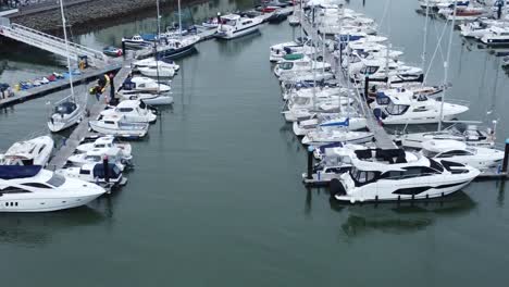 aerial birdseye view across wealthy luxury yachts and sailing boats moored in quaint conwy town harbour