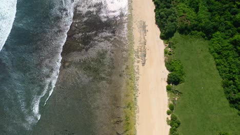 aerial top down view of empty white sand beach at nyang nyang in uluwatu bali on sunny day