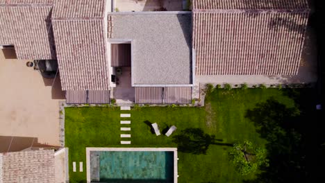 Foto-Superior-De-Una-Casa-Provenzal-En-El-Sur-De-Francia-Con-Su-Piscina-De-Piedra-Bali-Y-Su-Pequeño-Jardín-Verde,-Los-Azulejos-Son-Del-Sur.