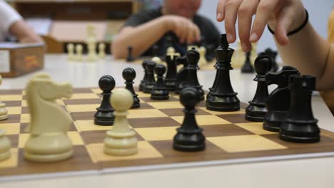 niños jugando al ajedrez en el tiempo libre, divirtiéndose, cierre de manos moviendo figuras, cámara lenta
