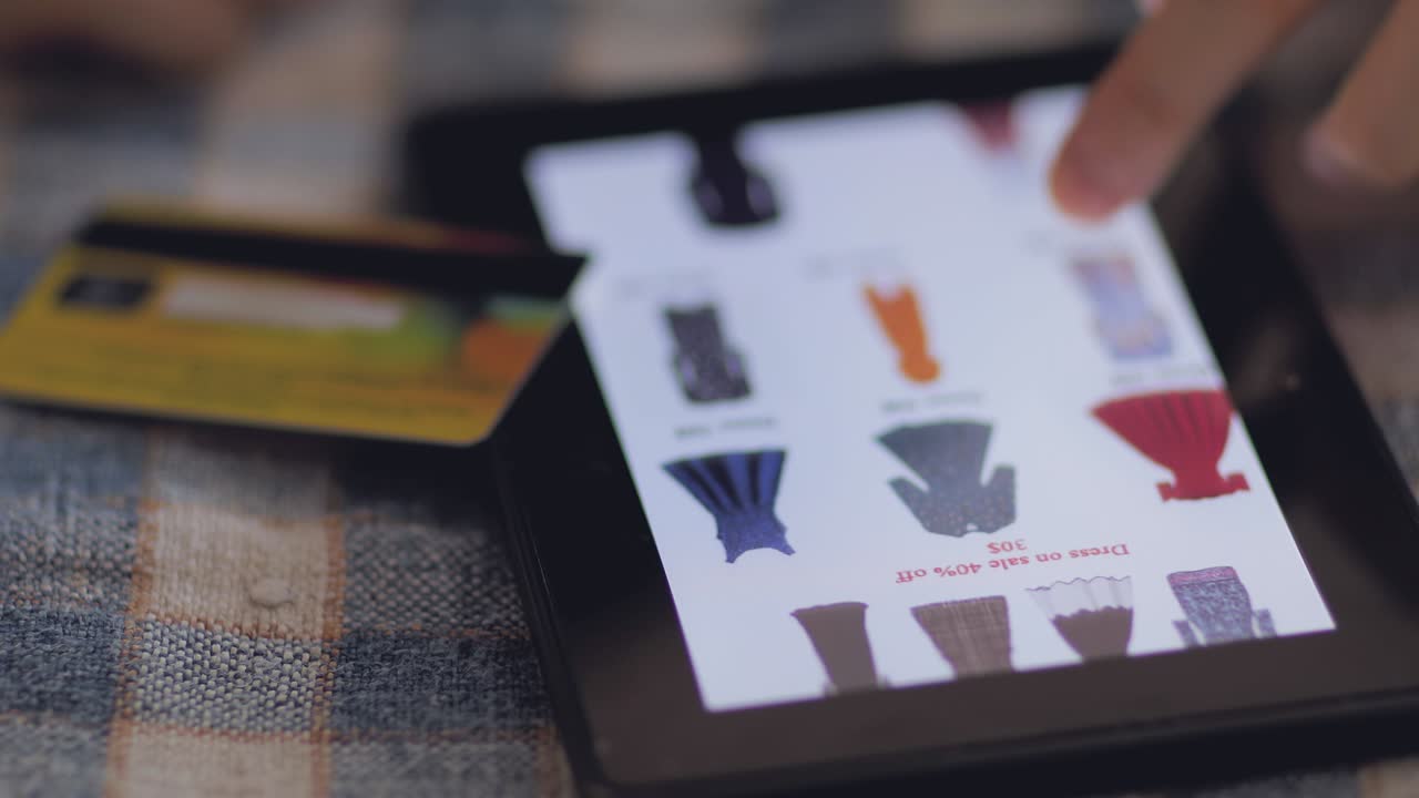 mirando vestidos femeninos en la tableta y haciendo compras en línea.