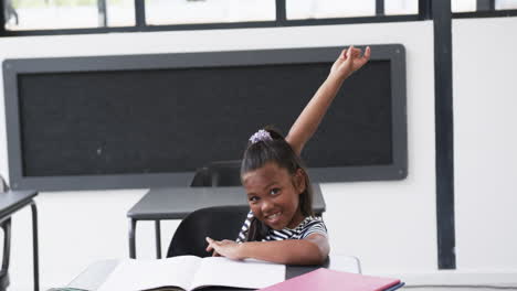 In-a-school-classroom,-a-young-African-American-girl-raises-her-hand