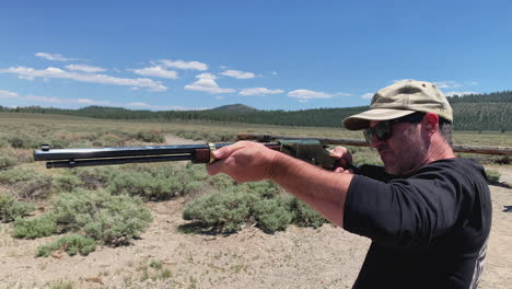 Male-gun-hobbyist-firing-gold-trim-lever-action-rifle-at-desert-shooting-range,-pedestal-shot