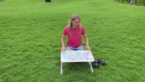 mujer sentada en el césped con una mesa portátil
