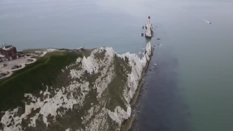 4k 30fps aerial drone flight over the white cliffs at the needles in the isle of wight showing the red and white lighthouse out at sea