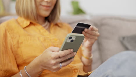 teléfono celular, tarjeta de crédito y una dama en un sofá haciendo