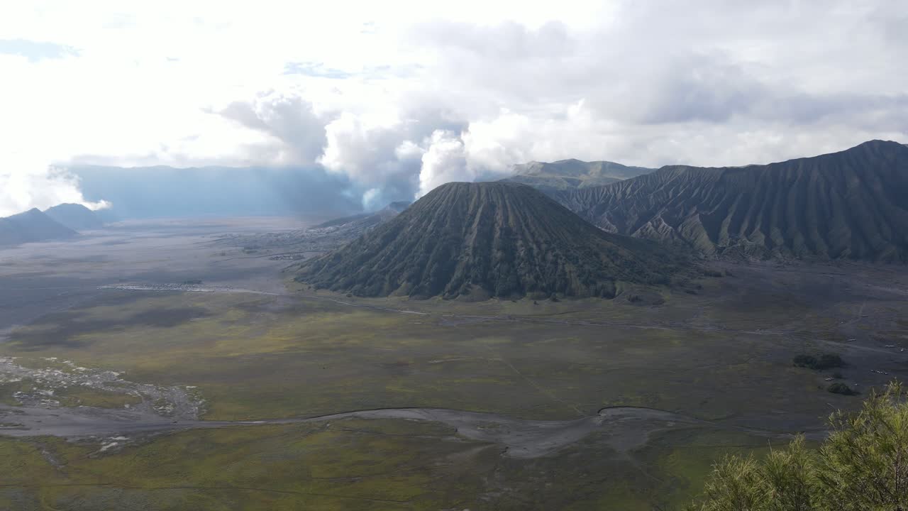 vista aérea, por la mañana, la hermosa zona del monte bromo está ligeramente humeante y la sabana es verde