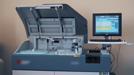 Automated machine at work and the computer screen in the laboratory room. Analysis blood at hospital laboratory. Blood samples in a robotic machine with 3D display.