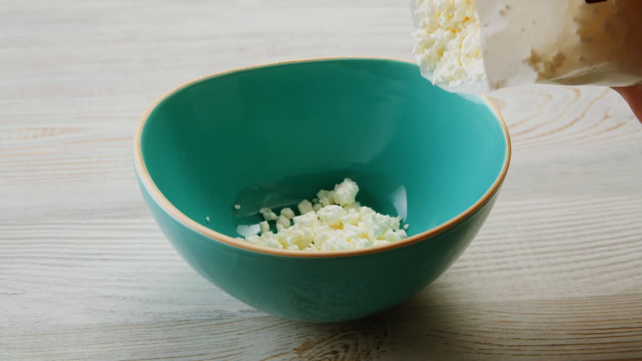 vertiendo queso cottage en un cuenco