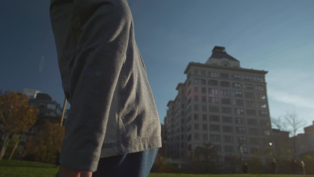 120fps 슬로우 모션으로 웃는 얼굴로 웃는 얼굴로 맨하탄 다리 아래 공원에서 뛰는 소년