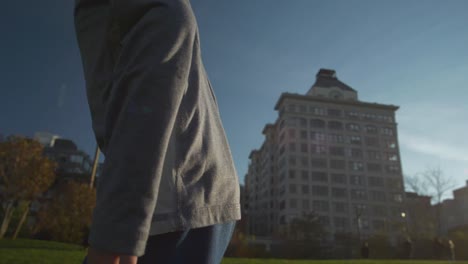 Niño-Sonriendo-Riendo-Y-Corriendo-En-Un-Parque-Bajo-El-Puente-De-Manhattan,-En-Cámara-Lenta-De-120-Fps,-Con-El-Sol-En-La-Cara