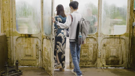 people walking through old doors in a greenhouse