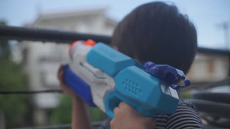 Footage-of-a-little-caucasian-boy-playing-with-a-water-gun-toy