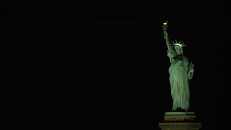 estatua de la libertad en su pedestal con cielo nocturno negro