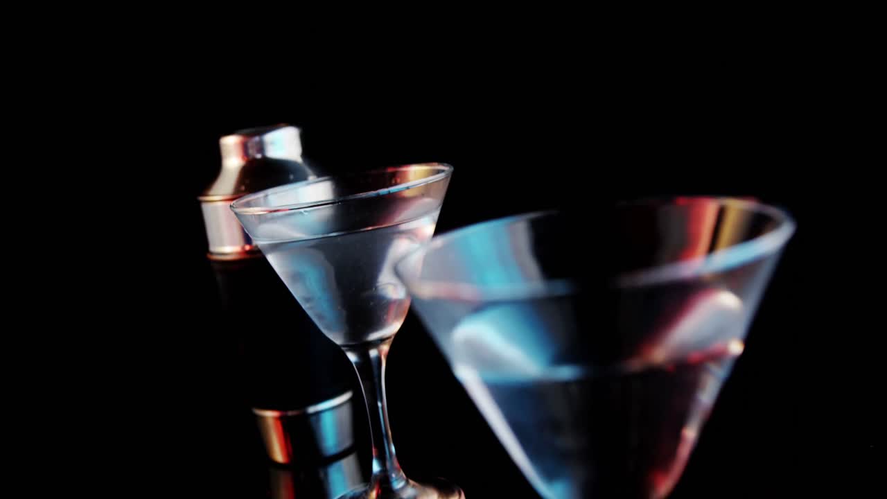 aceitunas cayendo en dos copas de cóctel