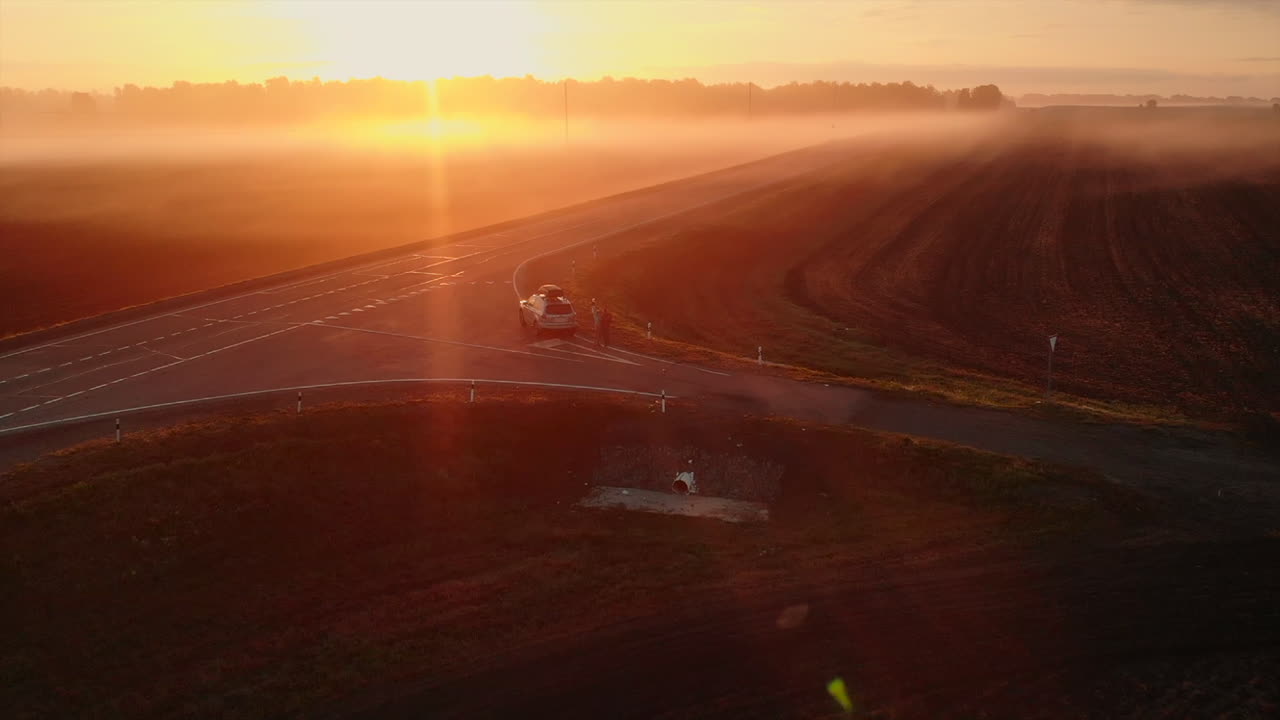 Sunrise over a Field with Fog and a Road