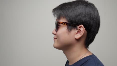 young chinese man delighted with his new pair of stylish sunglasses