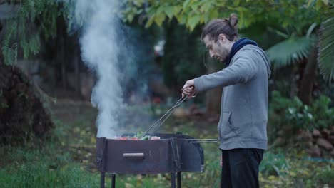 man grilling barbecue in garden