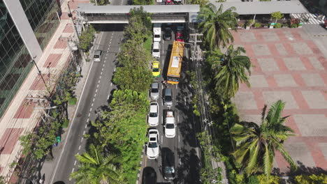 traffic jam on city street line with palm trees in rama iv road, bangkok, thailand. aerial drone shot