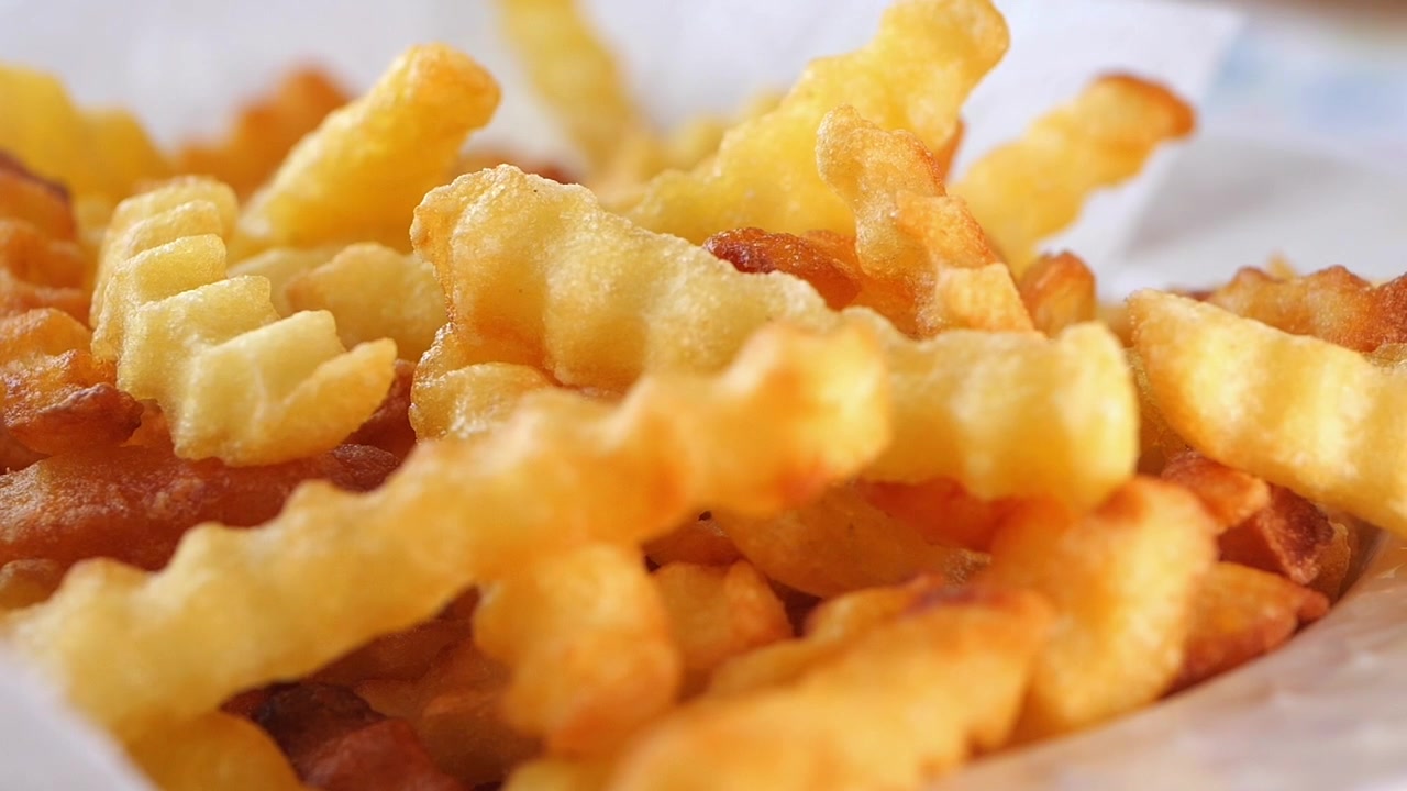 Nyfriterade vågiga pommes frites serverade på en tallrik