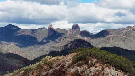 wide landscape view of the warrumbungle mountains with rocky outcrops and bushland, captured in natural daylight with slow horizontal camera pan