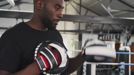 Entrenador-De-Boxeo-Masculino-Con-Boxeadora-En-El-Gimnasio-Usando-Guantes-De-Entrenamiento-Sparring-En-Ring