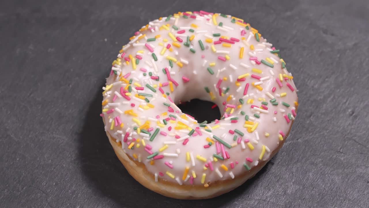 el donut dulce gira sobre un fondo oscuro. la dulzura tradicional estadounidense