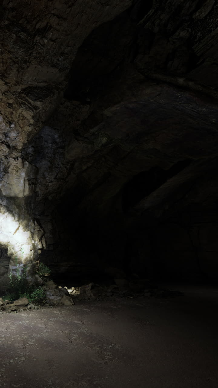 Una grotta oscura con pareti rocciose e raggi di luce che filtrano