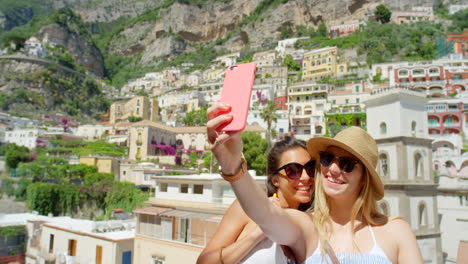 two happy young women taking selfies together