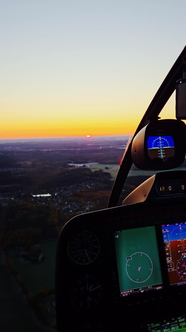 Early morning flight across Latvia with pilot's hand silhouetted in golden dawn