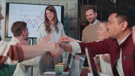 successful business deal happy smiling male and female managers shake hands, celebrate with team at office slow motion.