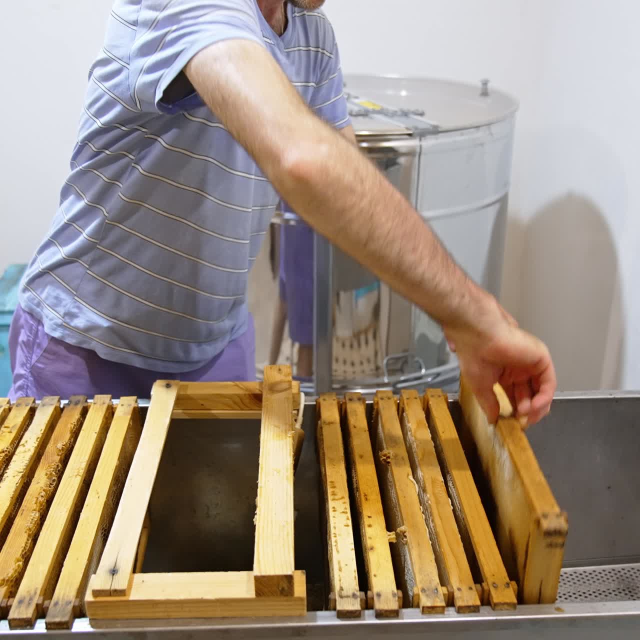 Telai completi predisposti per l'estrazione del miele vengono collocati in una grande scatola di metallo. Apicoltore che raccoglie il miele in una stanza apposita