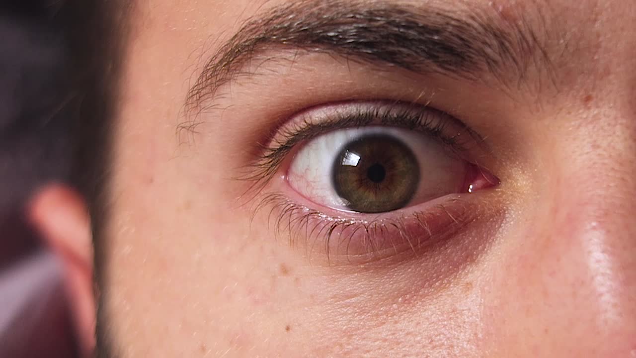 Man with green eyes sleeping and waking up.