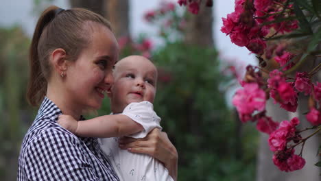 Amongst-palm-trees-and-blossoming-flowers-at-the-resort,-a-mother-playfully-embraces-her-child-with-hugs-and-kisses.-The-setting-resonates-with-the-happiness-of-a-united-family