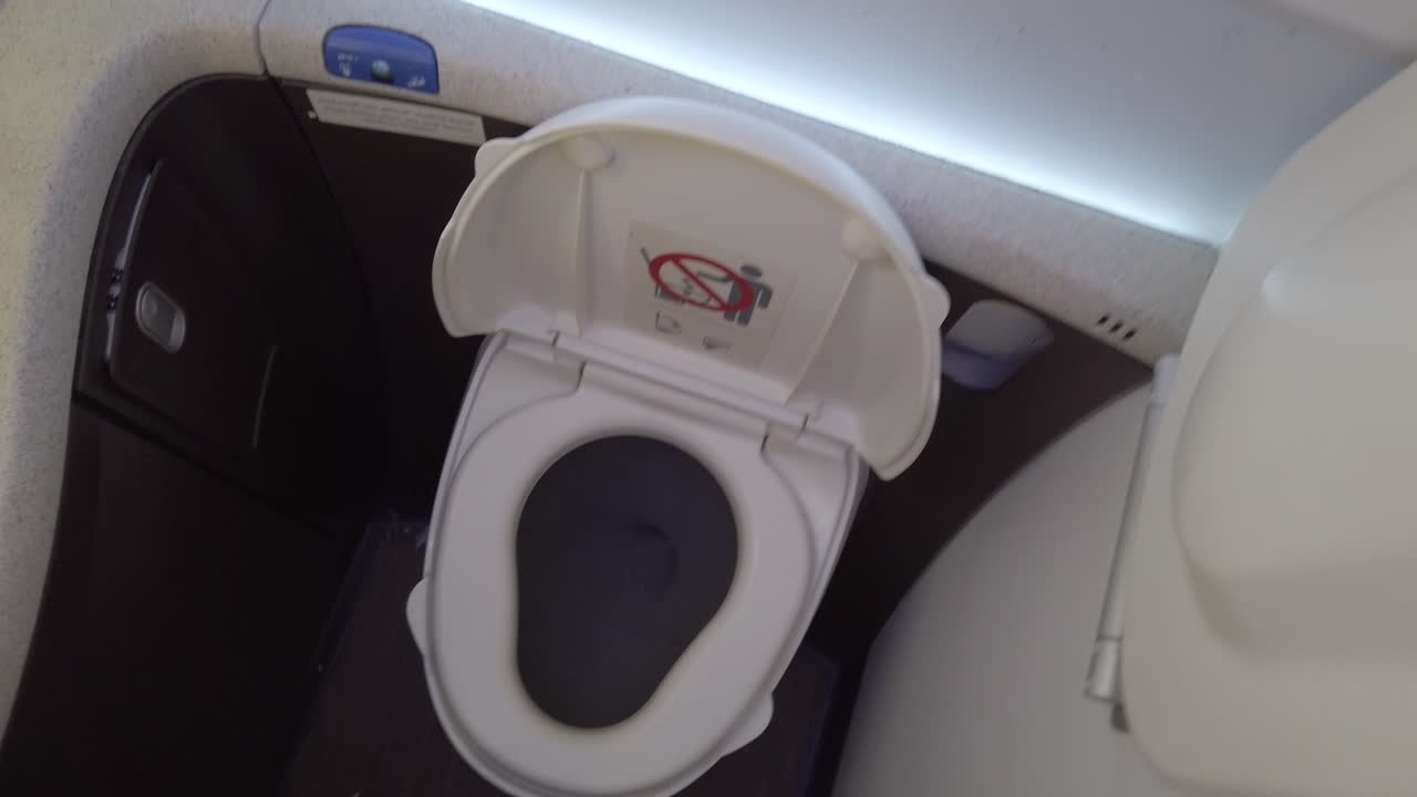 una toma fpv de la activación de la descarga de agua en el inodoro en un avión