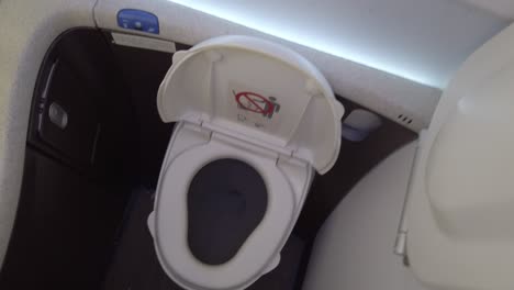 a fpv shot of the activating water discharge in the toilet in a plane