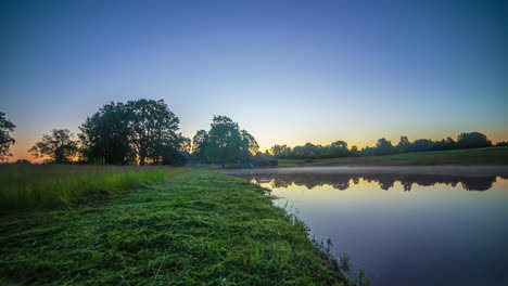 Wide-shot-time-lapse-of-bright-sunrise-over-natural-lake-in-nature-with-Beautiful-colors