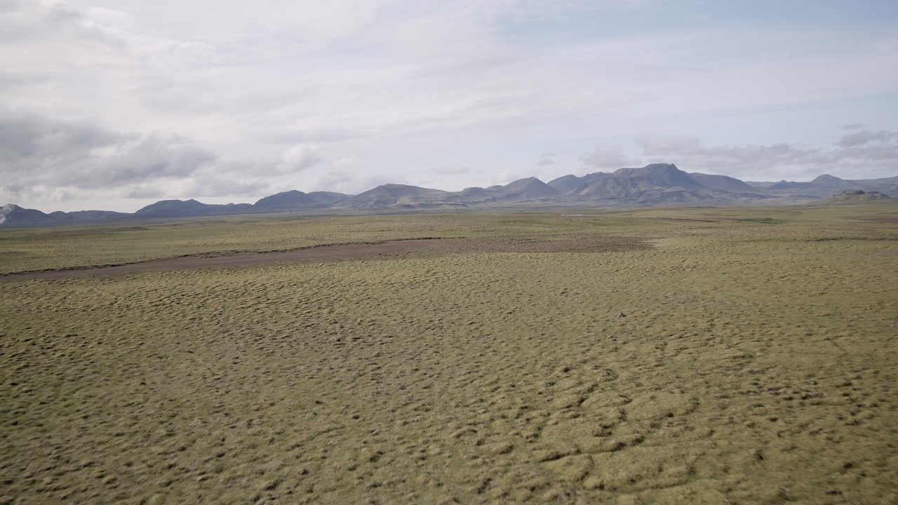 Nesjavellir landscape aerial push in over the plains towards mountains