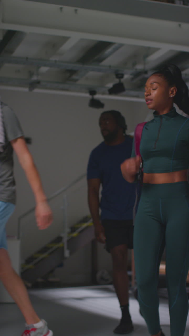 Vertical Video Of Male And Female Athletes In Fitness Clothing Training In Gym Changing Rooms Before Or After Exercise Class
