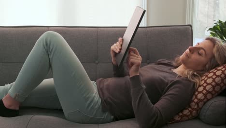 attractive young woman scrolling through her tablet