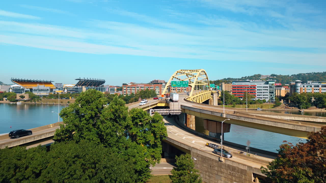 Pittsburgh, USA, 2 August 2025: Flight over the park at the river waterfront. Approaching the bridge with lively traffic. Pittsburg, Pennsylvania, USA