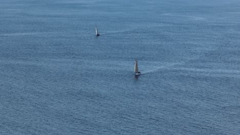 sailboats sailing across the open sea slow-motion aerial